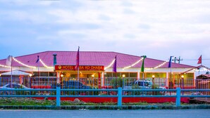 A hotel with a red roof and multiple flags.
