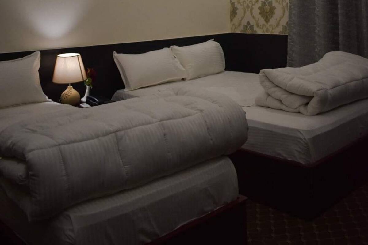 A double bed with a headboard, a bedside lamp, and a nightstand.