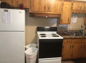 Efficient kitchen with a refrigerator, stove, and sink, perfect for meal preparation.