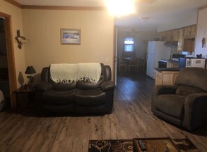 Relax in this inviting living room with a comfortable sofa, a small table, and a warm atmosphere.