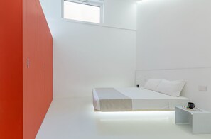 Une chambre à coucher moderne avec un lit, une table de chevet et une fenêtre.
