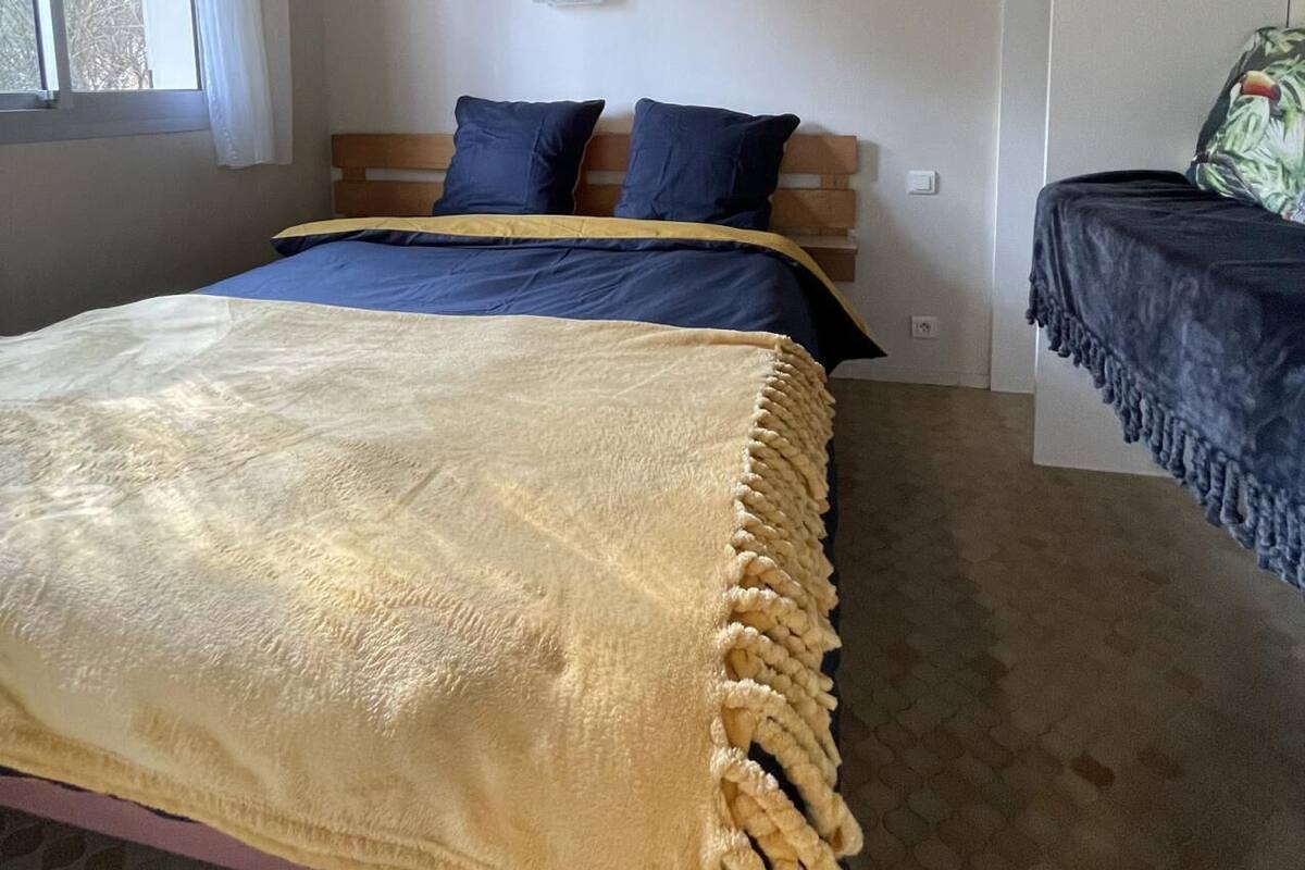 Ein Schlafzimmer mit einem Bett, einem Fenster, einem Deckenventilator und einem Etagenbett.