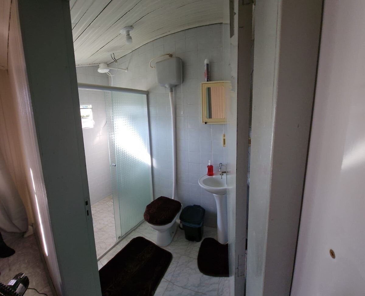 Un baño pequeño con inodoro, lavabo y ducha.