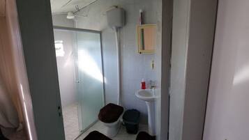 Un baño pequeño con inodoro, lavabo y ducha.