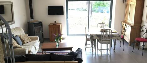 A living room with a sofa, a table with a vase, a TV, and a fireplace.
