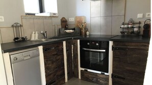 Una cocina con lavavajillas, horno y diseño de mueble de madera.