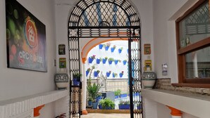 A hallway with a patterned ceiling, a decorative archway, potted plants, and a colorful rug. - Arc House Mezquita - Adults Only (Córdoba)
