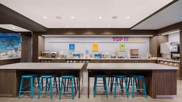 A modern breakfast area with a large island and bar stools, featuring a sign that reads "TOP 1 BREAKFAST".