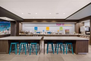 A modern breakfast area with a large island and bar stools, featuring a sign that reads "TOP 1 BREAKFAST". - Tru By Hilton Destin (Destin)