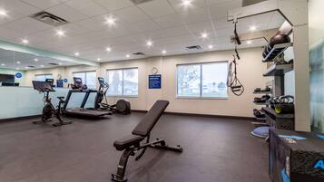 Una palestra con attrezzature per esercizi, una panchina e un tapis roulant.