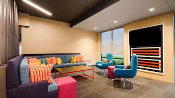 A modern living room with a sofa, armchairs, a coffee table, and a TV.