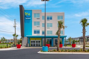 A modern hotel with a blue and grey facade, large windows, and a prominent 'tru by Hilton' sign. - Tru By Hilton Destin (Destin)
