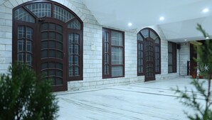 A corridor with arched windows and a tiled floor.