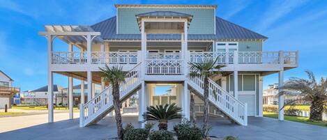 A two-story house with a balcony, a covered porch, and a staircase leading to the entrance.