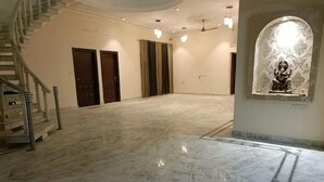 A spacious room with a marble floor, a staircase, and a statue in a niche. - Vehra Shagana Da, 4bhk, 2living (Jalandhar)