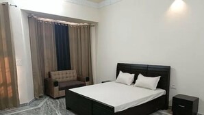 A bedroom with a bed, a chair, and a nightstand. - Vehra Shagana Da, 4bhk, 2living (Jalandhar)