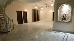A spacious interior with a marble floor, a staircase, and a statue in a niche. - Vehra Shagana Da / 8 bedrooms/ Punjab (Jalandhar)