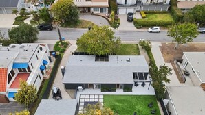 Ett bostadsområde med moderna hus, en välskött gräsmatta och en klar himmel.