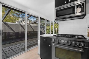 A modern kitchen with a gas stove, oven, and microwave.