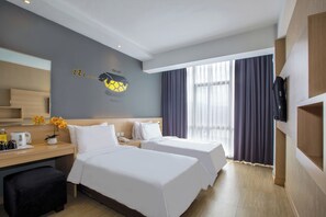 A hotel room with two beds, a desk with a coffee maker, a TV, and a large window with curtains. - Rooms Inc BTC Pasteur (Bandung)