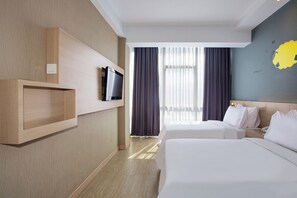 A hotel room with two beds, a TV on a wooden shelf, a nightstand, and a window with curtains. - Rooms Inc BTC Pasteur (Bandung)