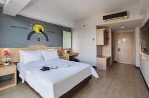 A modern hotel room with a large bed, a desk, a wardrobe, and a bathroom visible through an open door. - Rooms Inc BTC Pasteur (Bandung)