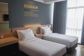A hotel room with two beds, a wall-mounted TV, and a large window with curtains. - Rooms Inc BTC Pasteur (Bandung)
