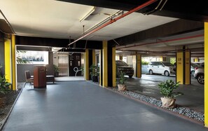 Eine Parkgarage mit mehreren Ebenen, gelben Säulen und einem Sicherheitsdienst.
