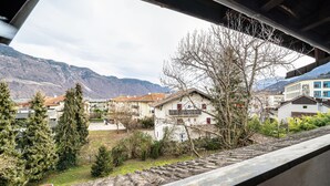 Un quartiere residenziale con case, una montagna sullo sfondo e un albero in primo piano.