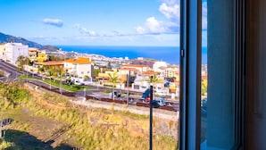 Un pueblo costero con edificios, una carretera y vista al mar.