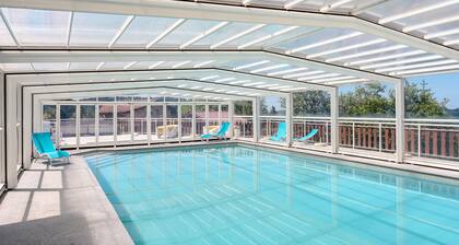 Chalet 'Chalet Les Moraines 8' avec vue sur les montagnes, piscine partagée et terrasse privée.