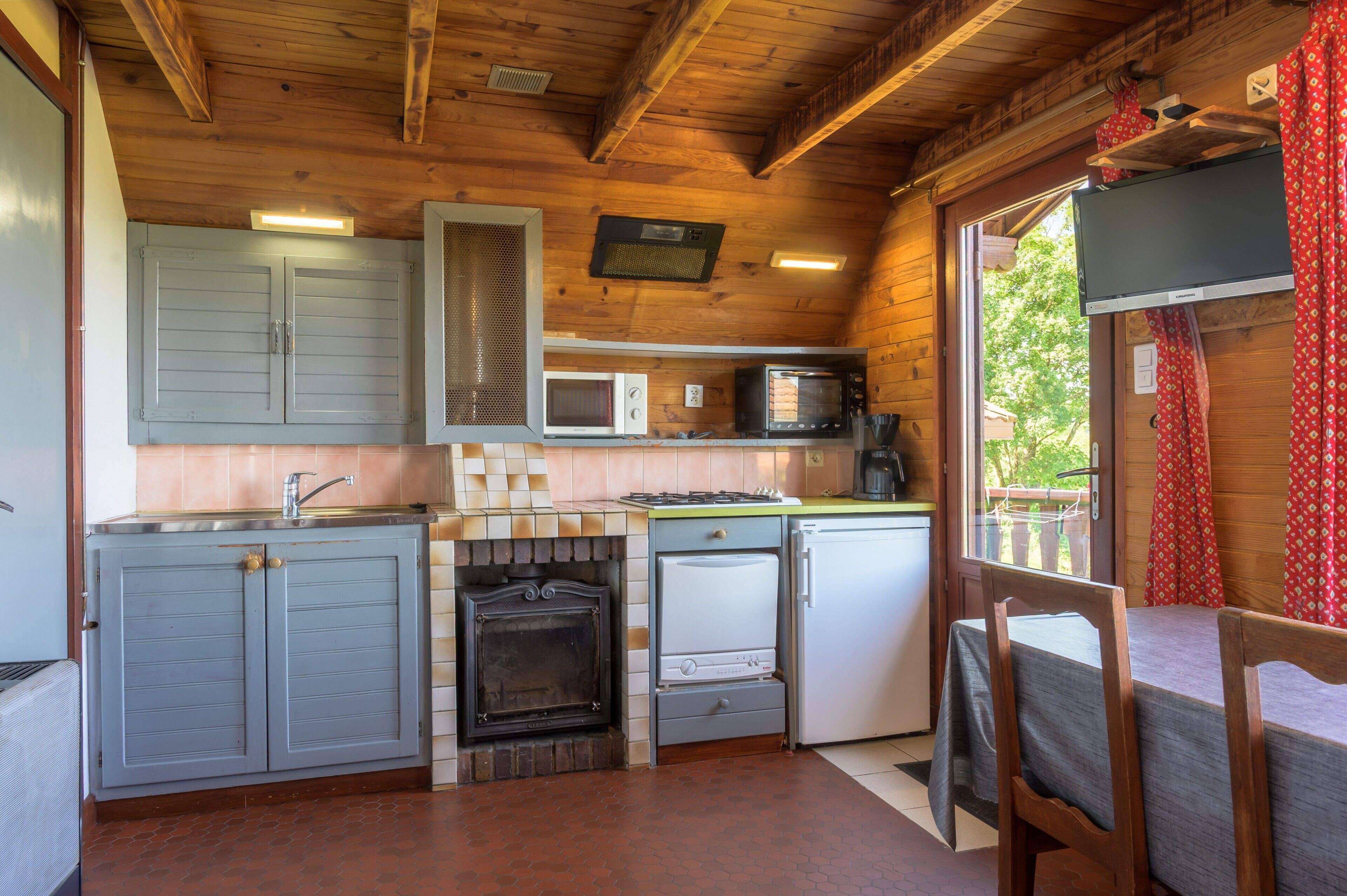 A compact kitchen with a microwave, stove, and refrigerator.