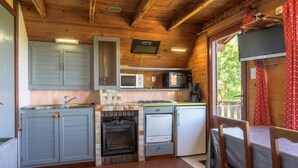 A compact kitchen with a microwave, stove, and refrigerator. - Chalet 'Chalet Les Moraines 8' with Mountain View, Shared Pool and Private Terrace (Le Tholy)