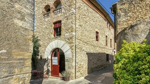 A stone building with a red door, arched windows, and a balcony. - Holiday Home 'Vermella' with Wi-Fi (Orriols)