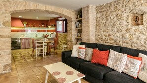 A living room with a sofa, a coffee table, and a kitchen in the background. - Holiday Home 'Vermella' with Wi-Fi (Orriols)