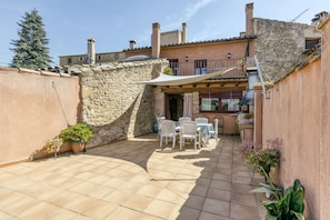 A patio with outdoor furniture, a water tank, and a stone wall.