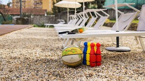 A beachside lounge area with sun loungers, a volleyball, and a set of colorful paddles. - Holiday Home 'Il Gattino Di Porto Appartamento 1' with Shared Pool, Wi-Fi and Air Conditioning (Imperia)