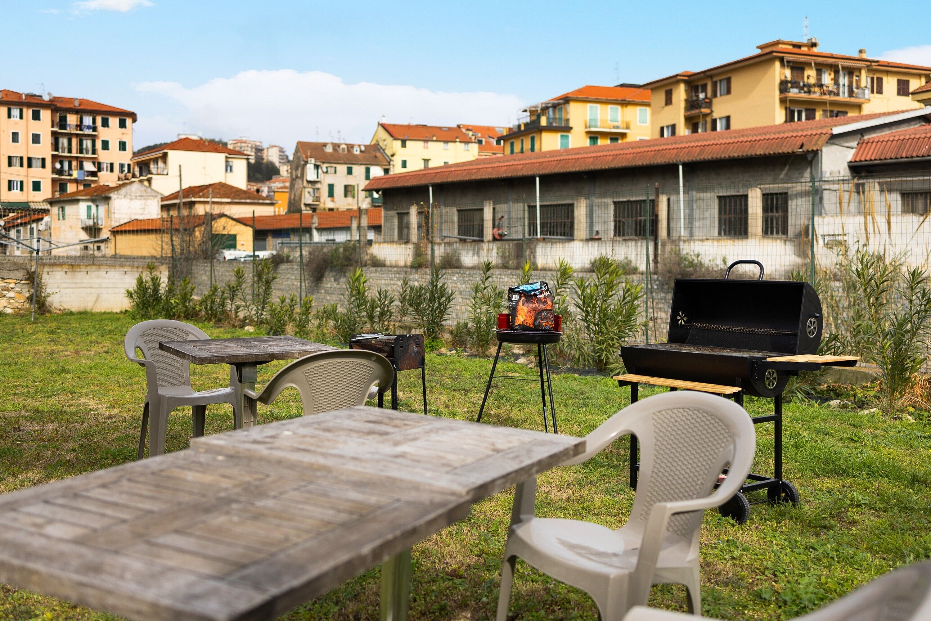Eine Außenpatio mit Grill, Stühlen und einem Tisch.
