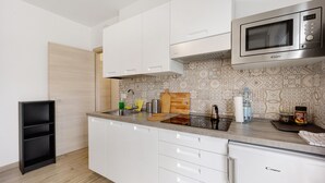 A modern kitchen with white cabinets, a microwave, and a sink. - Holiday Home 'Il Gattino Di Porto Appartamento 2' with Shared Pool, Wi-Fi and Air Conditioning (Imperia)