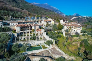 A hillside village with traditional architecture, a central courtyard, and a mountain backdrop.