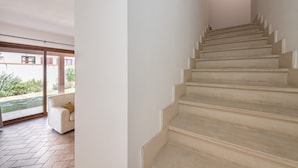 A staircase leading to an upper floor, a glass door entrance, and a white sofa with a cushion. - Holiday Home 'Girasole' with Private Terrace, Garden and Air Conditioning (Pula)