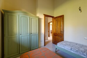 Una habitación con una cama, un armario y una puerta que da a otra habitación.
