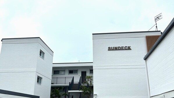 Un bâtiment moderne dont la façade porte l’inscription « SUNDECK ».