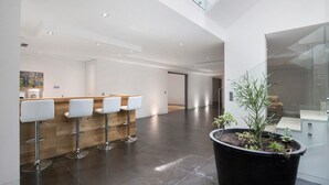 Ein modernes Interieur mit einer Rezeption, Barhocker und einer Zimmerpflanze.