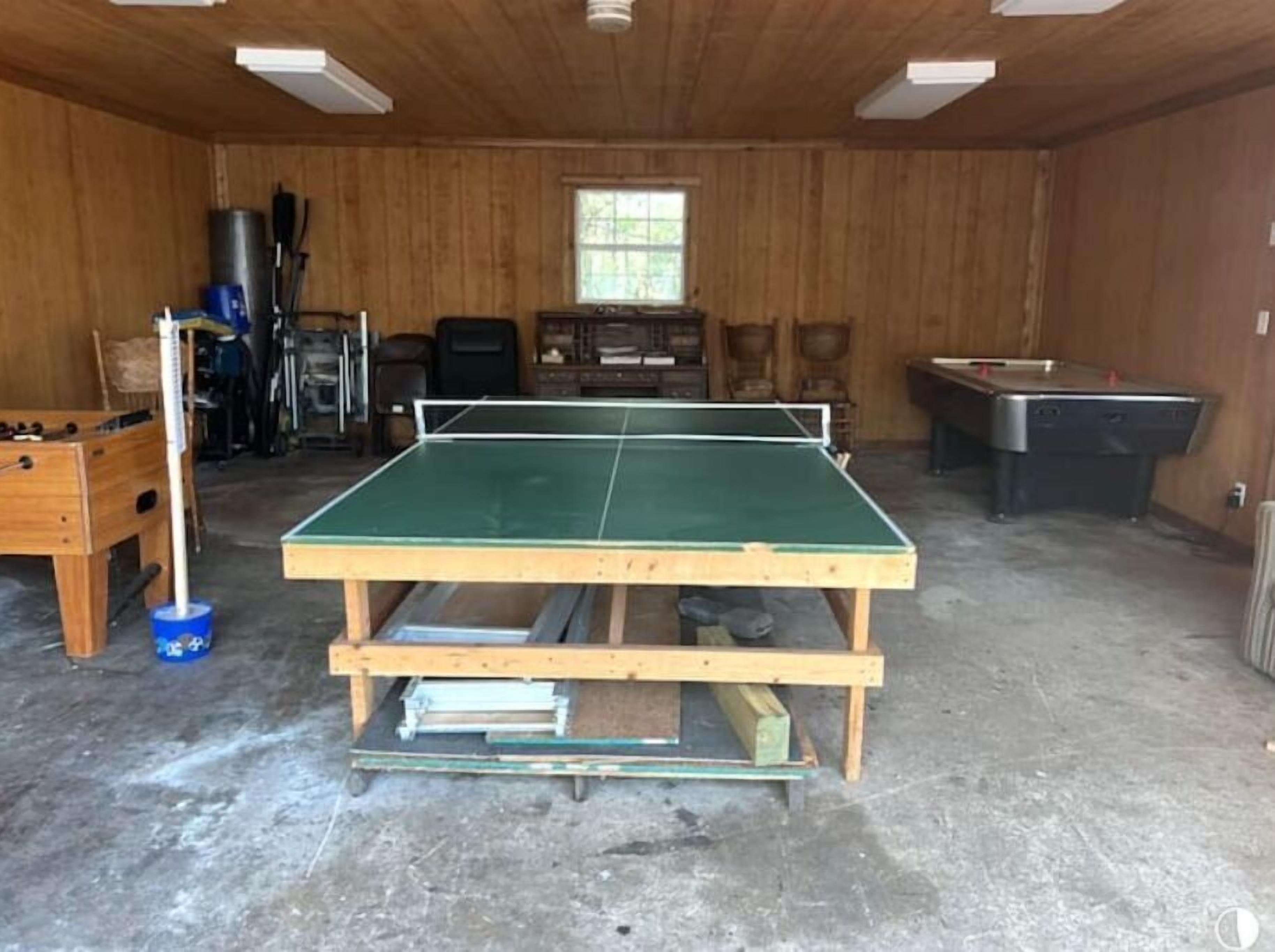 Una habitación con mesa de ping pong, mesa de futbolín y mesa de billar.