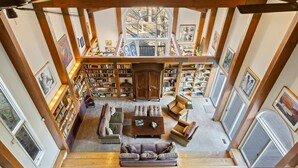 Una biblioteca amplia con techos altos, estanterías de madera y zonas de estar acogedoras.
