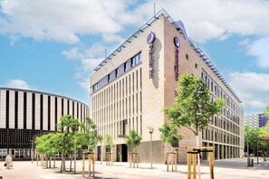 A modern building with a curved facade, a prominent entrance, and a clear sky. - Premier Inn Dresden City Prager Straße (Dresden)