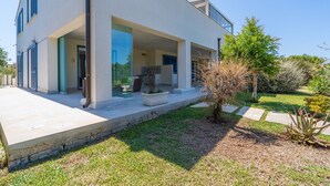 A modern two-story house with a covered patio, a small garden, and a clear sky. - Villa 'Melus Maris' with Sea View, Pool, Garden, Terrace & Wi-Fi (Siracusa)