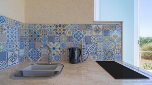 A kitchen with a sink, a kettle, and a black mat on the counter. - Villa 'Melus Maris' with Sea View, Pool, Garden, Terrace & Wi-Fi (Siracusa)