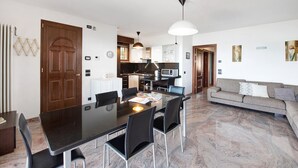 Una cocina moderna con comedor, sofá y un amplio ventanal.